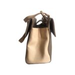 Bolso HNA de color café, material piel vegana, en la parte lateral del bolso viene en color nude, asa estática en la parte superior de color nude para ser tomado con la mano, detalles metálicos en color dorado