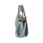 Bolso HNA de color azul cielo, material piel vegana, en la parte lateral del bolso viene en color azul cielo, asa estática en la parte superior de color azul cielo oscuro y azul cielo claro para ser tomado con la mano, detalles metálicos en color dorado.