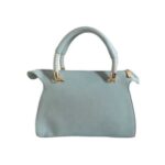 Bolso para dama HNA en la parte trasera de color azul cielo, material piel vegana, textura complemente lisa, asa estática en la parte superior de color azul cielo oscuro y azul cielo claro, detalles metálicos en color dorado.