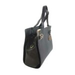 Bolso para dama HNA de color negro, material piel vegano, tiene un broche colgante en metálico de color dorado con el logo de la marca en la parte de enfrente, adicional tiene dos broces en forma de correa corta en material metálico, de color dorado y estático en las esquinas del bolso, asa estática del color del bolso en la parte superior para tomar de la mano, asa ajustable para usar en manos libres del color del bolso.