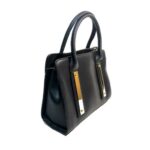 Bolso para dama HNA en color negro, material piel vegana, viene con detalles en metal de color dorado en el frente del bolso, asa estática en la parte superior del color del bolso para usar con la mano.