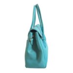 Bolso HNA de color azul, material piel vegana, broche en asa estática en la parte superior del color del bolso para tomar con la mano, detalles decorativos en metal de color dorado.