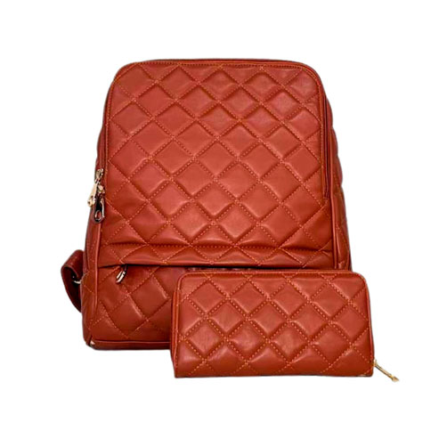 Mochila para dama de color marrón, material piel vegana, cierre en la parte superior cerrar la bolsa en material metálico y de color dorado, correas pectorales en color marrón para ser ajustado en los hombros, detalles metálicos en color dorado, cuenta con una bolsa tipo cartera.