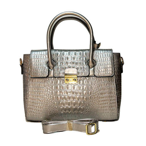 Bolsa para dama en color plata, material piel vegana, en sus partes extremas viene con dos agarraderas para colocar las correas, asa estática de color plata en la parte superior de la bolsa para llevar a la mano, asa ajustable en color plata para ajustarse en manos libres, viene con detalles decorativos de material metálico en color dorado, cuenta con relieve de cocodrilo en todo el diseño de la bolsa.